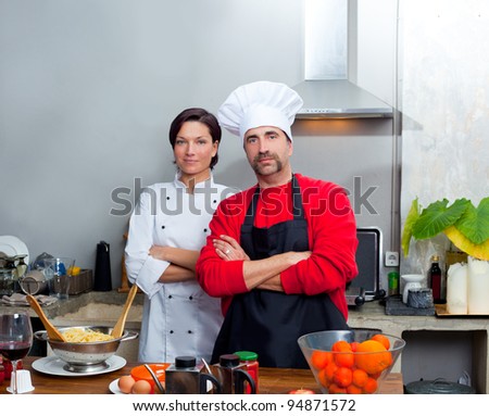 Chef couple man and woman posing in kitchen with uniform