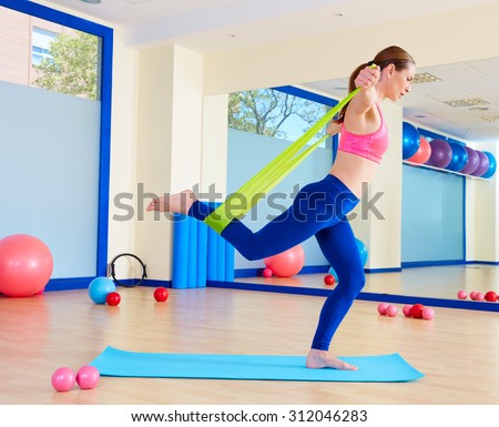 Pilates woman standing rubber band exercise workout at gym indoor