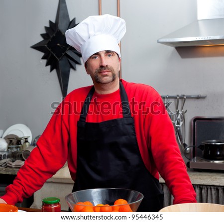 Chef man portrait with mustache in black and red on the kitchen
