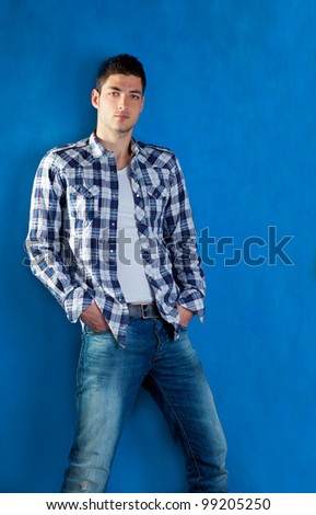 stock-photo-handsome-young-man-with-plaid-shirt-denim-jeans-in-blue-background-99205250.jpg
