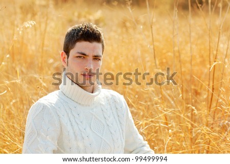 Autumn winter man portrait in outdoor dried grass field with turtleneck sweater