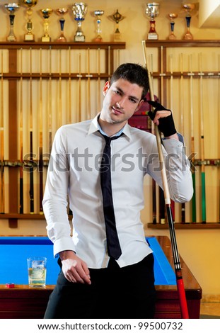 Billiard handsome young winner man with shirt tie and cue at trophy club