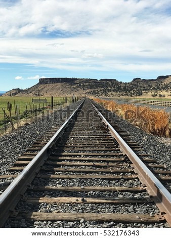 Railroad tracks run along farmland in Crook County in Central Oregon on a fall afternoon.