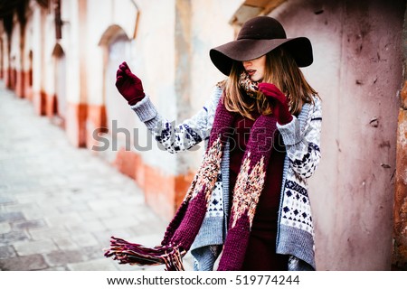 lady in the hat   throws a  red  scarf aside