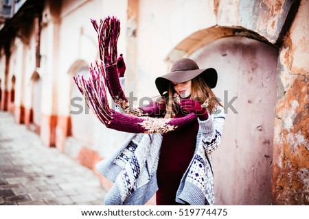 woman in the hat throws a red scarf aside