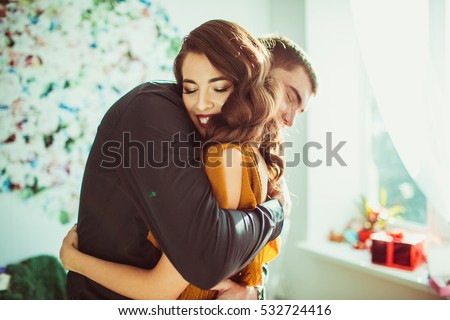 Beautiful lady leans to man\'s shoulder while he hugs her