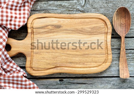 Cooking background - cutting board with spoon and towel on wooden kitchen table.food background concept.