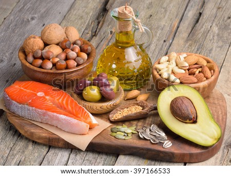 Selection of healthy fat sources on wooden table.