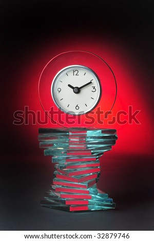 Modern glass clock with red glow background.
