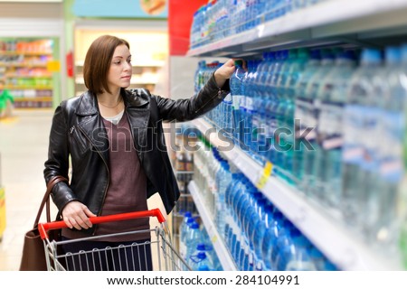 woman buys a bottle of water in the store