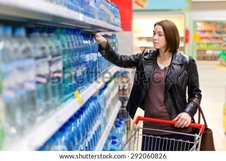 woman buys a bottle of water in the store