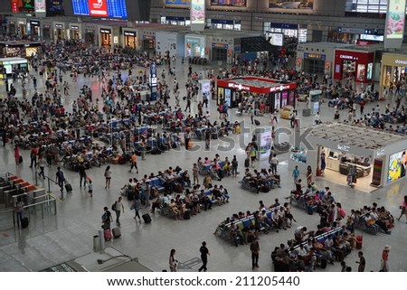 SHANGHAI, CHINA - August 16: crowd of passengers waits for a transport on one of the four major railway stations in Shanghai - Shanghai Hongqiao Railway Station on August 16. 2014 in Shanghai