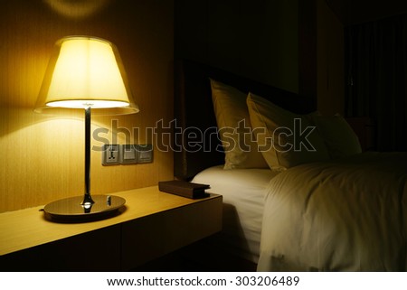 Night scene in hotel room, nightstand with lamp