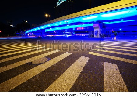 Night view of Crosswalk and pedestrian at modern city zebra crossing street. Light trails,Blur abstract.