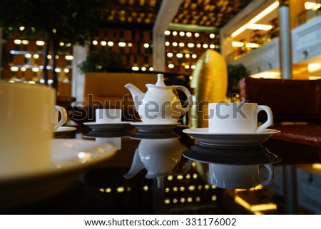 White Coffee cup on the table in lounge bar background.
