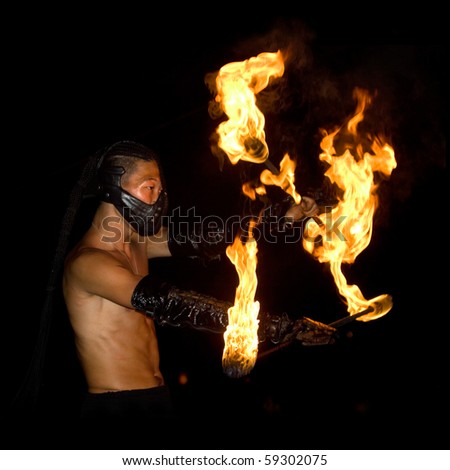 GOA, INDIA - JANUARY 20: A masked man spins fire with the double staff at Injuco Indian Juggling Convention on January 20, 2010 in Goa, India.