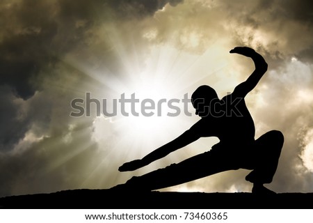 Man Practises Martial Arts with Dramatic Cloudy Sky in Background