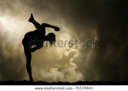 Man Practises Martial Arts High Kick Silhouette on Stormy Sky Background
