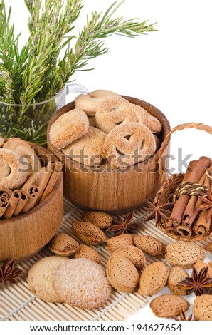 sweet sugar cookies in wooden containers with cinnamon sticks, almonds, anise asterisks, and a pitcher of rosemary