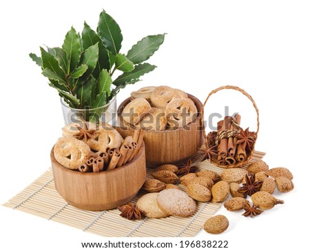 sweet sugar cookies in wooden containers with cinnamon sticks, almonds, anise asterisks, and a sprigs of laurel