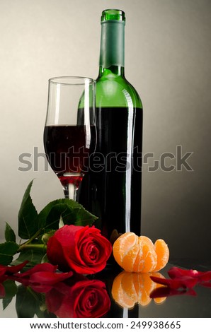 Red wine in the glass. Beverage and rose for romantic dinner