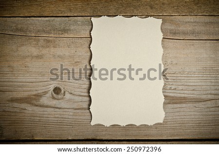 The piece of old white paper lying on a wooden background.vertical position