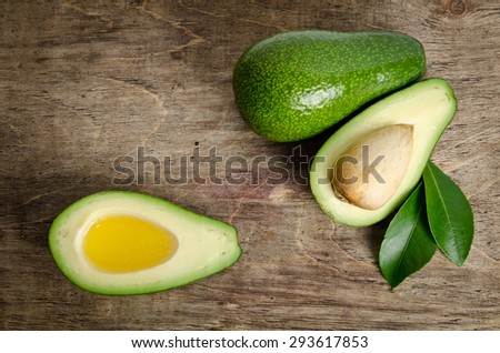 fresh avocado and  avocado like a bowl for oil on wooden background