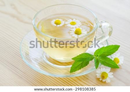 Cup of medicinal chamomile tea  on the wooden table