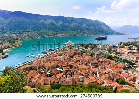 Looking over the Bay of Kotor in Montenegro with view of mountains, boats and old houses with red tile roofs