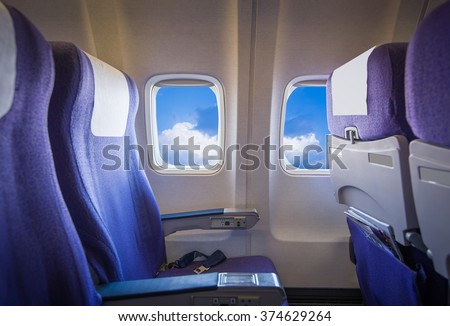 View of the sky and clouds with sunlight from the airplane window,empty seats.