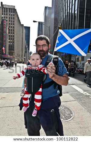 NEW YORK - APRIL 14:  A man and his unidentified baby hold a Scottish Flag while watching The Scotland Week Parade on 6th Avenue  April 14, 2011 in New York, NY.