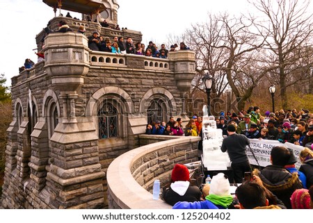 NEW YORK, NY - JANUARY 19: People watch artists sculpt an ice replica of Belvedere Castle during The Central Park Ice Festival at Belvedere Castle in Central Park January 19, 2013 in New York City.