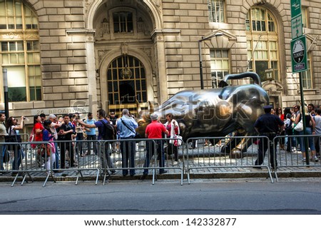 NEW YORK - JUNE 15:  New Yorkers and Tourist wait in line to take a picture of The Wall Street Bull Statue in Bowling Green Park June 15, 2013 in New York City.