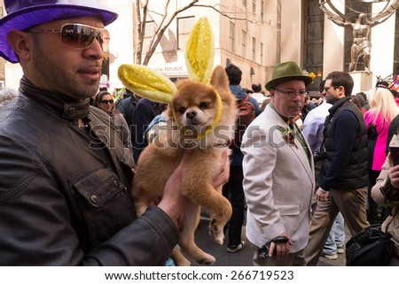 NEW YORK - APRIL 5:  A man dressed up with a dog in Bunny Ears during The 2015 Easter Parade and Easter Bonnet Festival in New York City