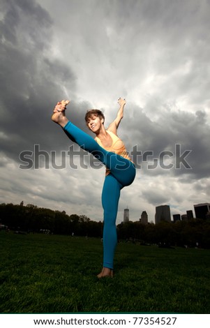 Young pretty woman in Yellow top doing yoga and exercising in Central Park