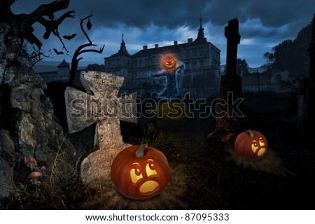 Jack-o-lantern come alive in a cemetery near old castle