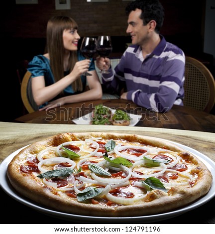 Couple drinking wine and eating pizza
