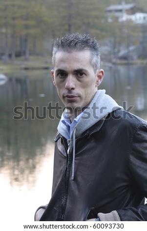 portrait of a man in the middle of nature in the background a mountain lake
