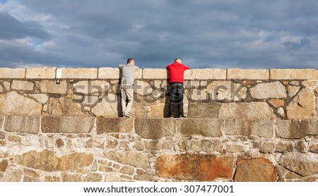 DUN LAOGHAIRE, IRELAND - August 15: Unidentified men watch fishing on Dun Laoghaire\'s East pier on August 15, 2015 in Dun Laoghaire, Ireland.