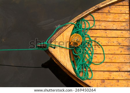Fisherman boat with ropes and float. Norway. Wooden boat made fast to the pier.