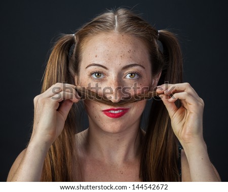 Funny portrait of a quirky girl playing with her pigtails.