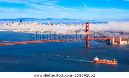 Fog rolling over Golden Gate Bridge and San Francisco on a late summer afternoon.