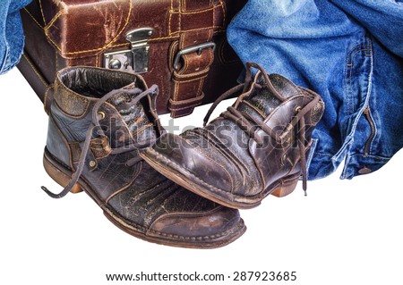 Vintage suitcase, old boots and jeans on white background