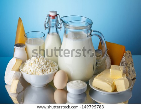Dairy Products, Milk, Cheese, Egg, Yogurt, Sour Cream, Cottage Cheese And Butter On Blue Background Still Life