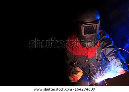Working welder on black background with copy space