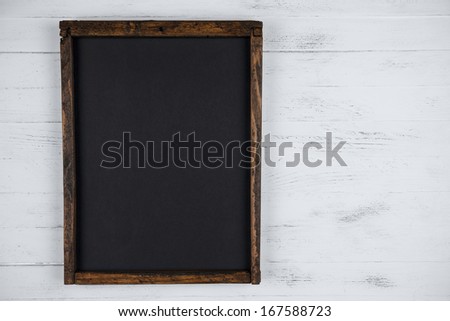 Blank chalkboard on white wooden background with copy space
