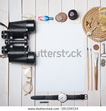 White blank paper sheet with lot of different creative stuff around it on wooden table