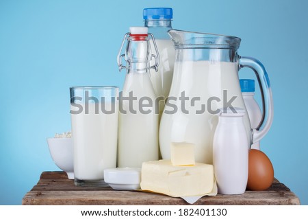Dairy products assortment on old wooden table, blue background