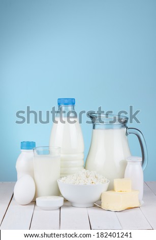 Dairy products assortment on wooden table, blue background, copy space