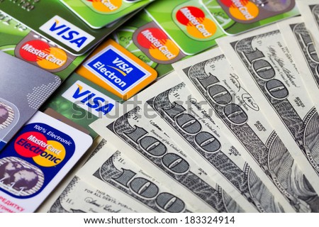 KIEV, UKRAINE - March 22: Pile of credit cards, Visa and MasterCard, credit, debit and electronic with US dollar bills, in Kiev, Ukraine, on March 22, 2014. Selective focus.